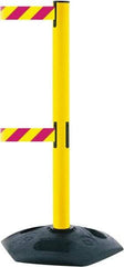Tensator - 38" High, 2-1/2" Pole Diam, 4 Way Stanchion - 19" Base Diam, Octagon Recycled Rubber Base, Yellow Plastic Post, 13' x 2" Tape, Dual Line Tape, For Outdoor Use - Apex Tool & Supply